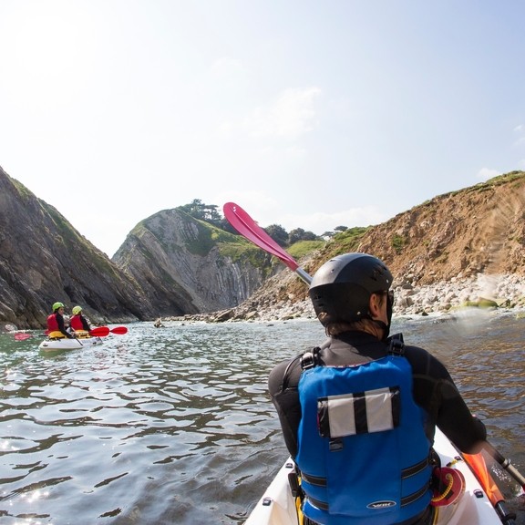 People kayaking along the shores of coastline
