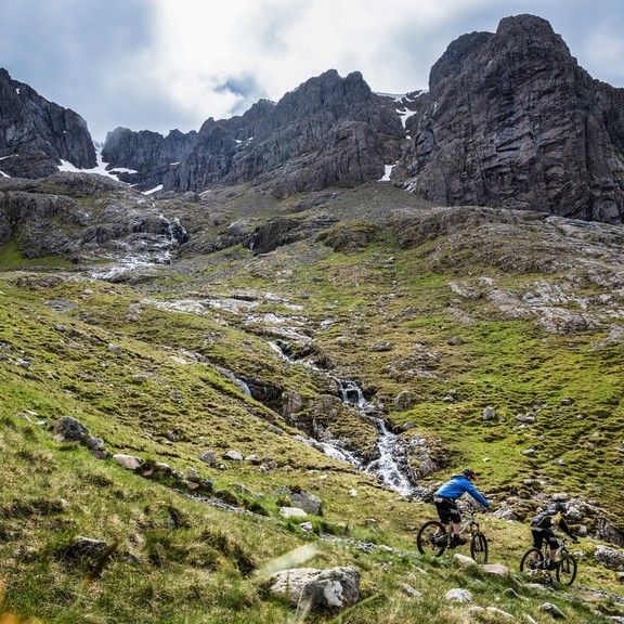 Two mountain bikers cycling downhill down a mountain
