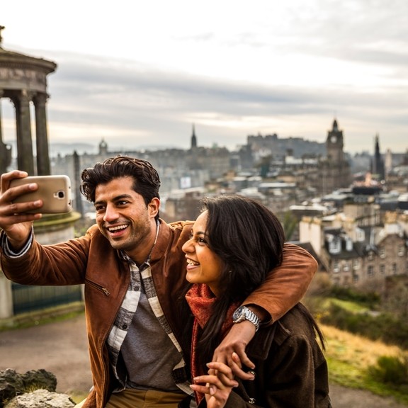 A young couple taking a selfie of view over historic town