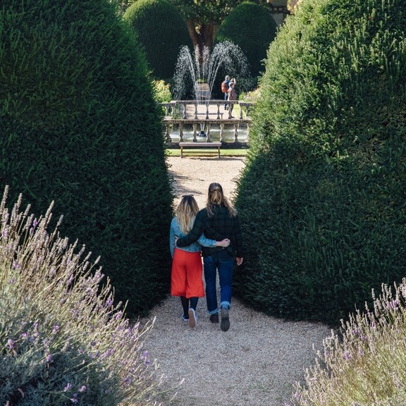 Male and female couple hugging in the garden near a fountain