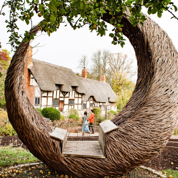 A crescent shaped bench outside Anne Hathaway's cottage, part of the Shakespeare's Birthplace collection in Stratford-upon-Avon.