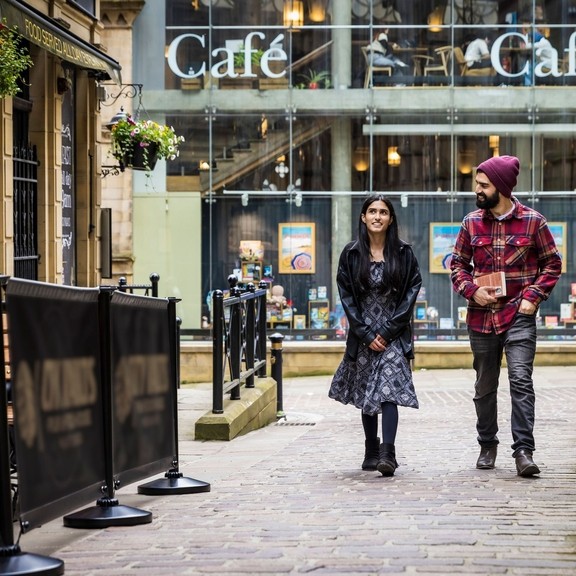 A woman and a man walk through a town centre