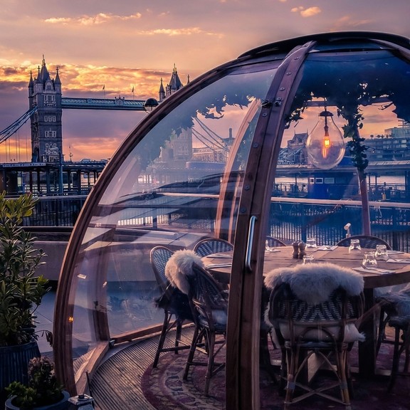 Wooden table under a glass dome with view of London skyline