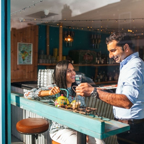Man and a woman enjoying food at window table