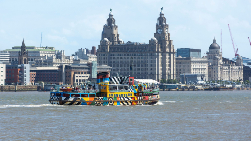 A view to a ferry on a river in front of an iconic building