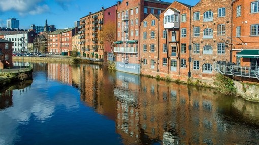 Warehouses lining the canal in Leeds against blue sky