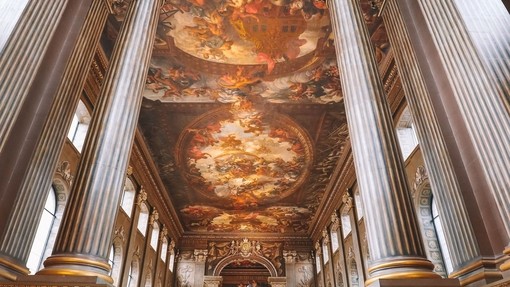 Man walking up a staircase. Painted night sky on ceiling
