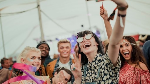 Group of friends taking a selfie at a music festival.