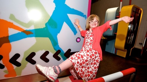Girl with Downs Syndrome, imitating an image on the wall in museum