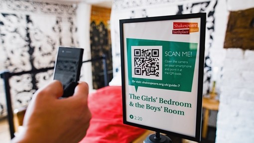 Close up of a hand scanning a QR code with a smart phone at the Shakespeare Birthplace Trust