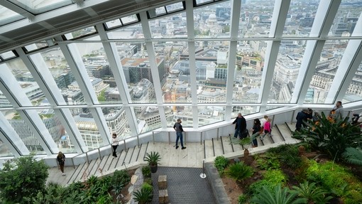People walking down the stairs Sky Garden wth the city in the background