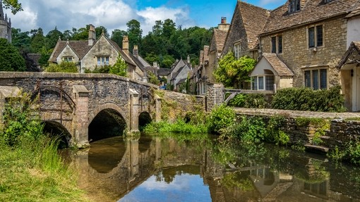 Blue skies and reflections in the picturesque Cotswold village of Castle Combe.