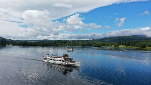 Visitors on a boat cruise on a lake with hills in the background