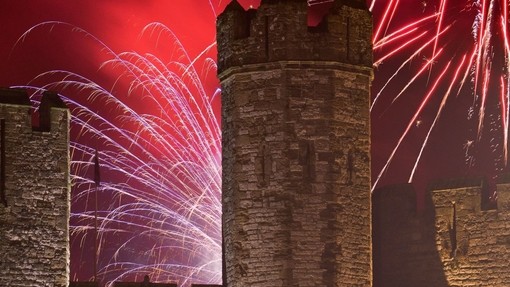 Big firework display over a castle at night