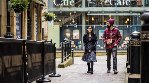 A woman and a man walk through a town centre