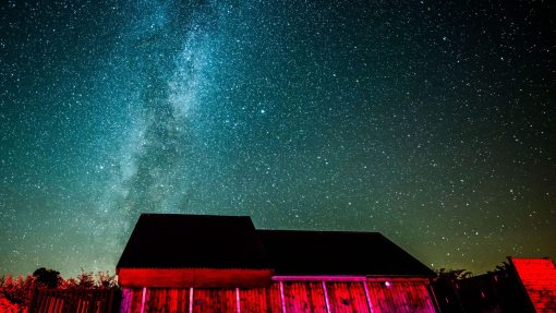 A dark sky observatory lit up at night under the sky.