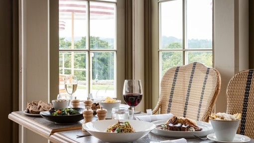 A table of food with wine in the Garden Room Restaurant at a luxury hotel on the grounds of a large country estate.