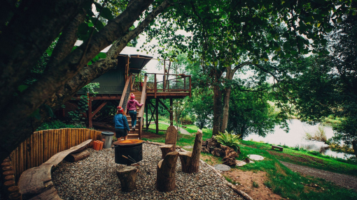 Friends glamping by the waters edge in a forest.