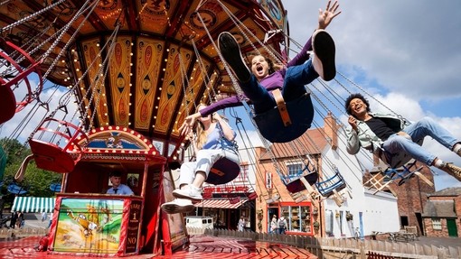 A family have fun on a fairground ride