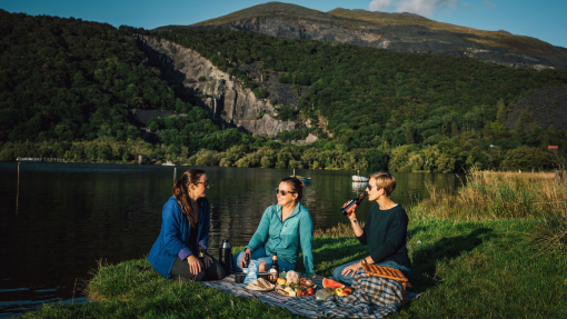 Friends having a picnic in grassland by a glacially formed lake.
