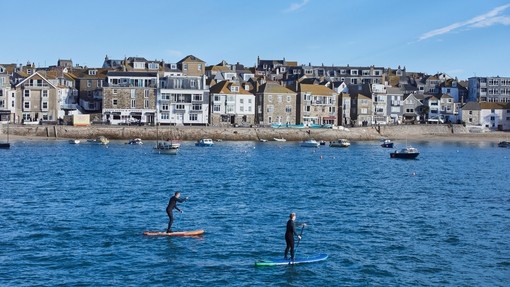 Stand up paddle-boarders in harbour, St. Ives, Cornwall, England.
