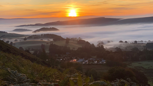 Sunrise and mist over countryside camping grounds.