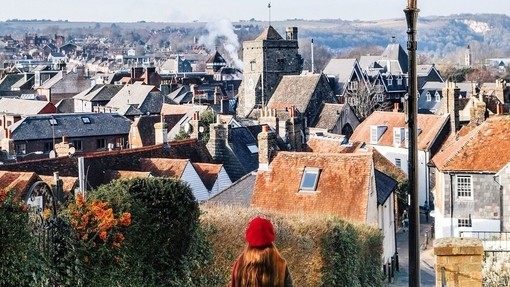 Girl looking down a countryside road to a village below