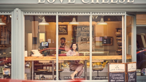 Woman sitting at a window table in a cheese cafe