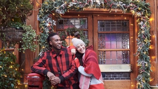 Couple in front of Christmas decorated entrance