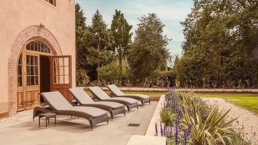 A row of deck chairs outside a luxury hotel and spa resort.