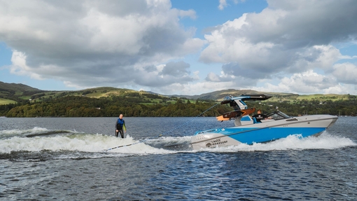 Young woman wake surfing on a pristine country lake.
