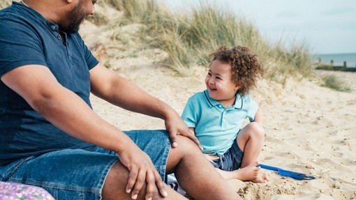 Father and 4 year old son with Down Syndrome at the beach.