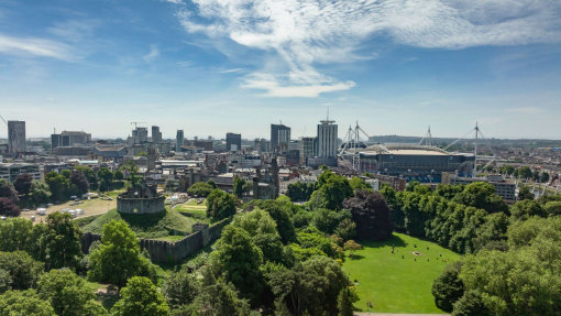 Aerial view of parklands, stadium and buildings of a city.