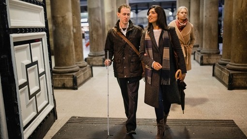 Man and woman walking into train station, Newcastle central station, UK
