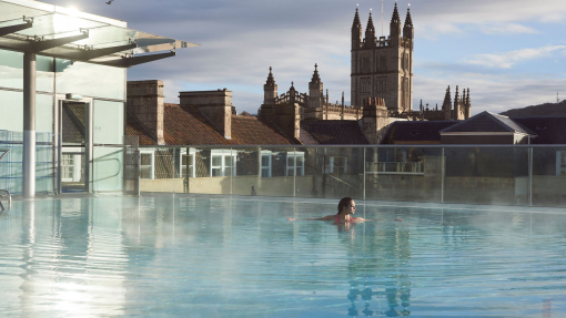 Woman in a roof top swimming pool at a spa