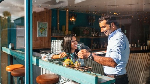 Man and a woman enjoying food at window table in a cafe.