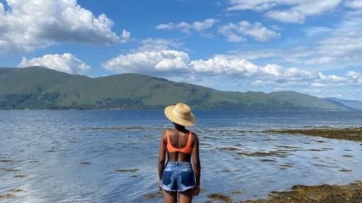 A woman stands on a rock looking over Loch Linnhe
