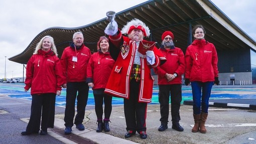 A group of people pose with a Town Crier