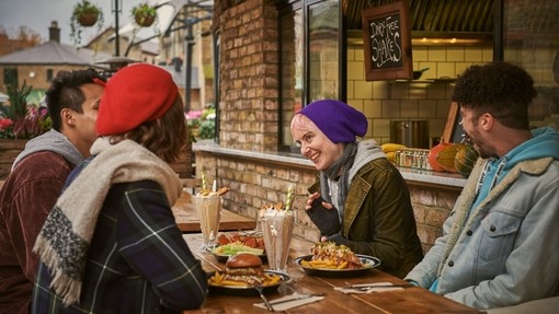 Friends eating a meal outside a restaurant