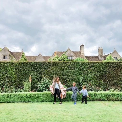 Mother and sons standing in garden in front of a tall hedge