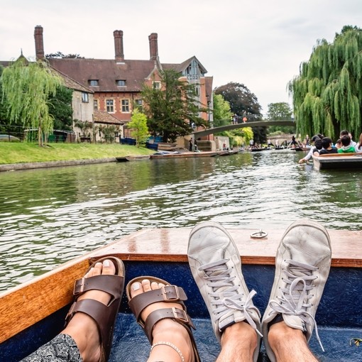 Two feet inside a boat; punting on a river