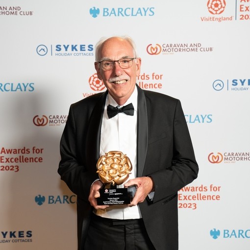 Photo of Tourism Superstar Winner at the VisitEngland Awards for Excellence 2023 - Geoff Colvin, Kent & East Sussex Railway - in front of the branded photo backdrop
