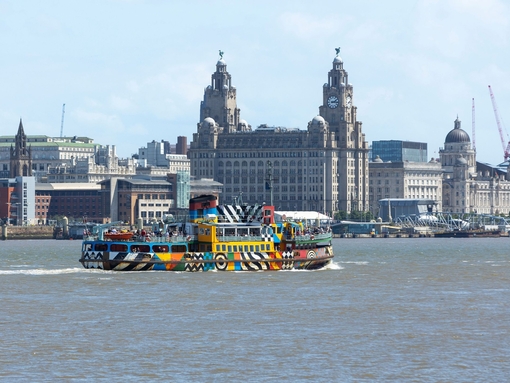 A view to a ferry on a river in front of an iconic building