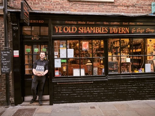 Man standing outside Ye Old Shambles Tavern