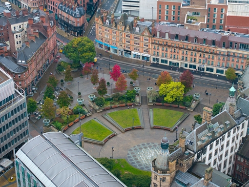 Aerial view of an expansive cityscape with garden and high-rise buildings