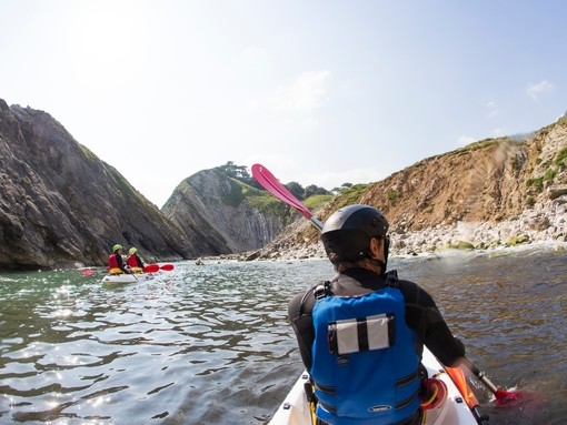 People kayaking along the shores of coastline