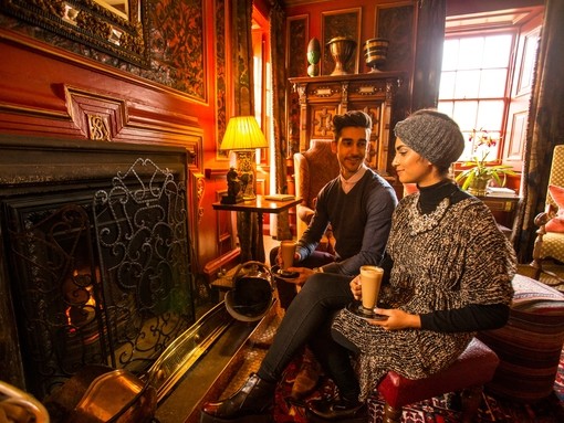 A young Arab couple relaxing by a fire in the drawing room
