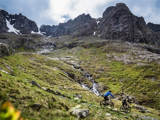 Two mountain bikers cycling downhill down a mountain
