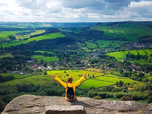 A woman with her arms raised enjoying the view from high