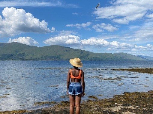 A woman stands on a rock looking over Loch Linnhe